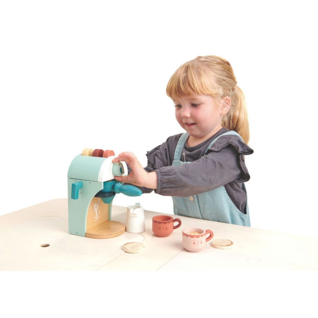 Child making a pretend babyccino with the Tender Leaf Toys wooden coffee machine