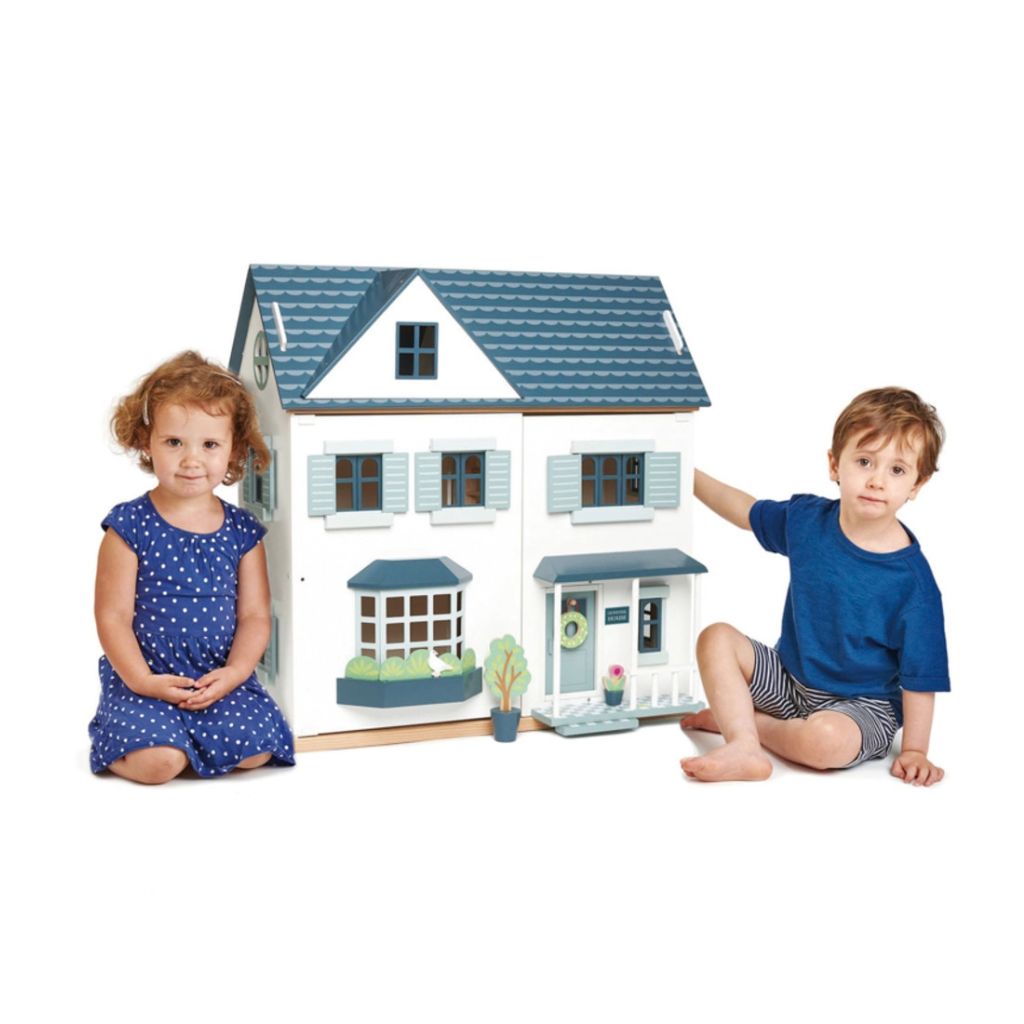 Child playing with doll figures in the Tender Leaf Toys Dovetail wooden doll house