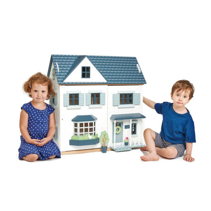 Child playing with doll figures in the Tender Leaf Toys Dovetail wooden doll house