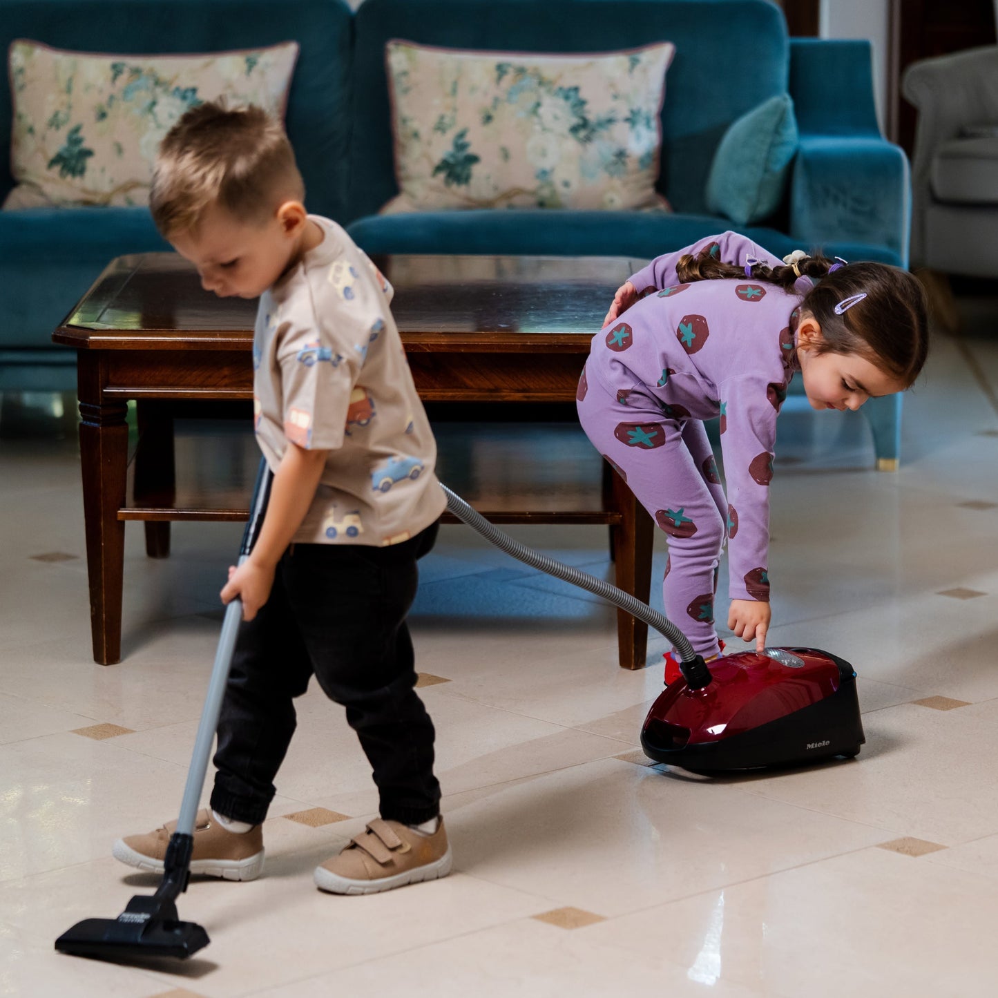 Children playing pretend cleaning with the Theo Klein Miele Vacuum Cleaner toy