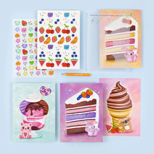 Kit contents laid out: illustrated background cards, full-colour transfer sheets and the rubbing tool