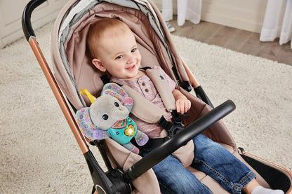 Baby lying on a play mat cuddling the VTech Cuddle & Sing Elephant soft plush toy during floor time