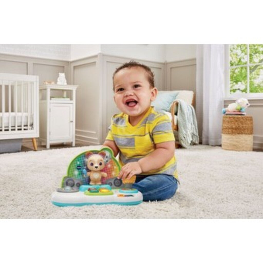 Baby sitting on a play mat tapping the DJ Jams Puppy deck while the lights flash