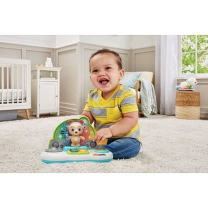 Baby sitting on a play mat tapping the DJ Jams Puppy deck while the lights flash