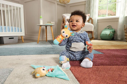 Parent holding a Forest Pals character above a baby during tummy time on a soft play mat