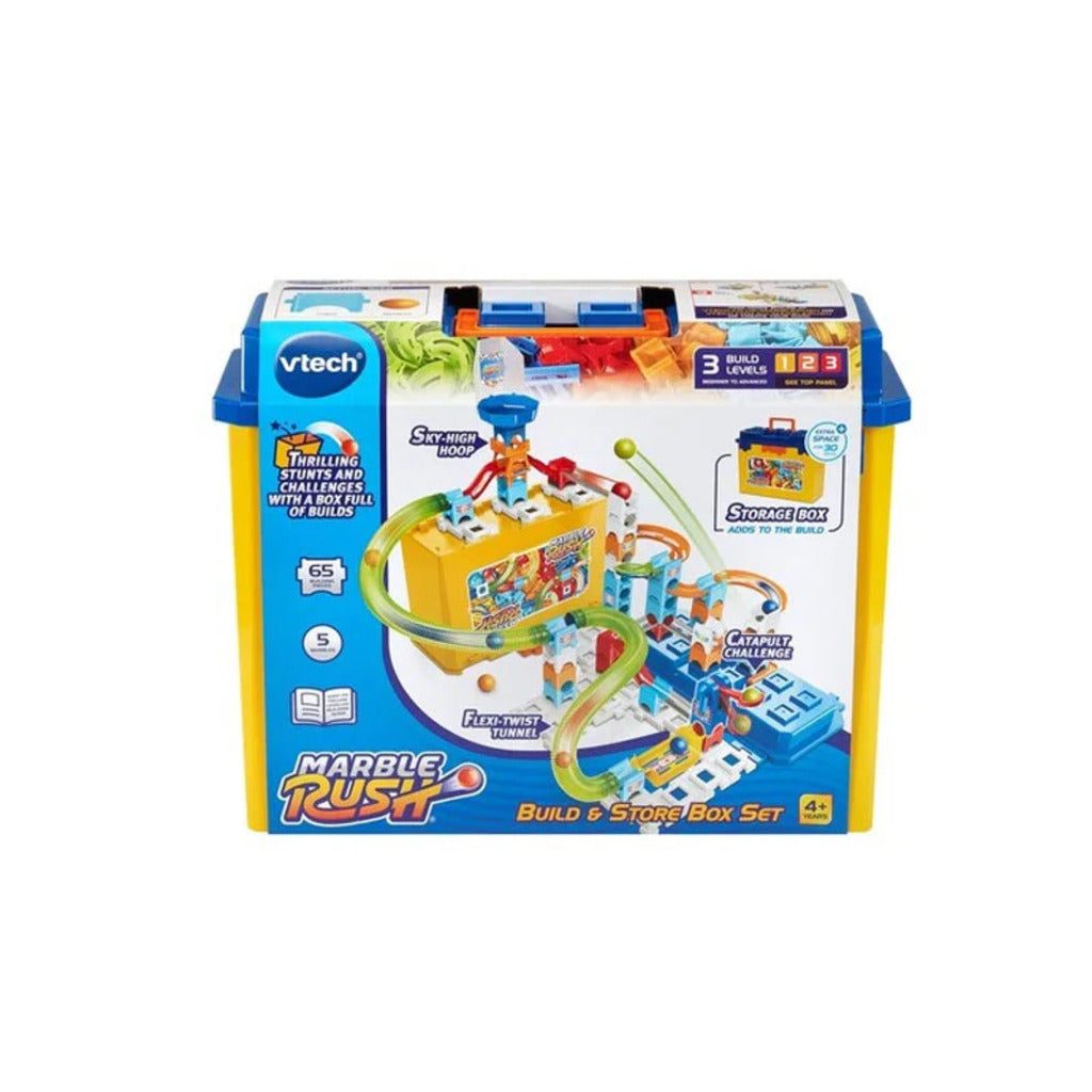 Child kneeling on a living room floor releasing a marble down a completed Marble Rush stackable track