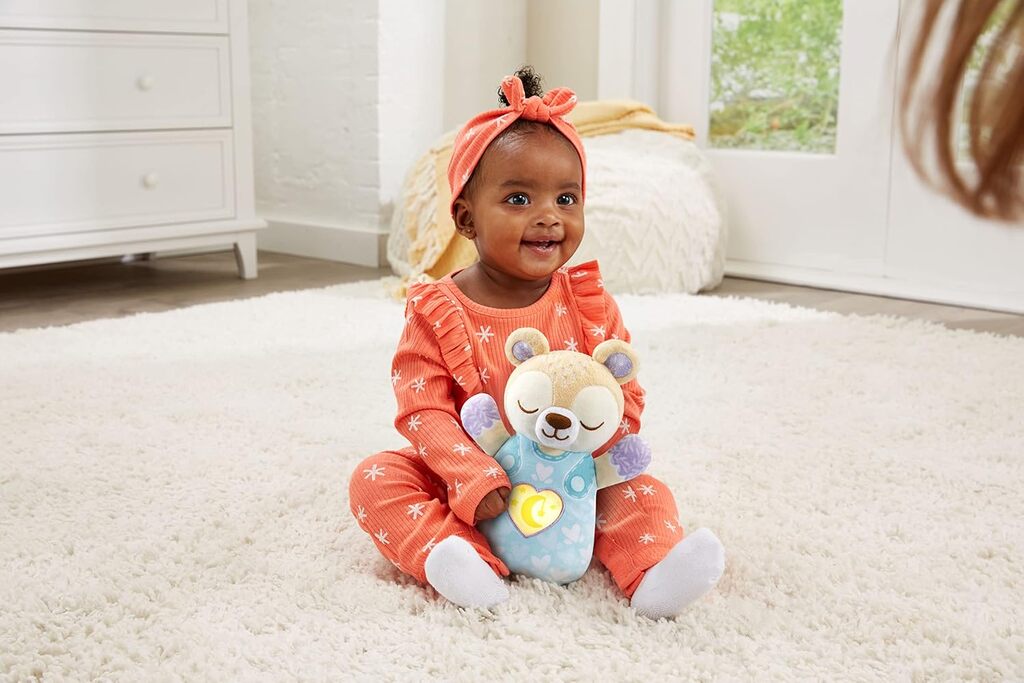 Close-up of the Soothing Bear glowing tummy panel and control buttons used to start lullabies