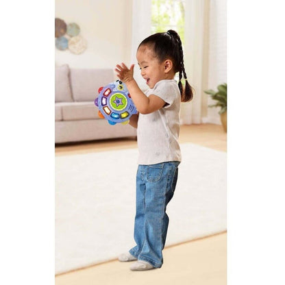 Toddler shaking the Tapping Tunes Tambourine while dancing in a bright living room