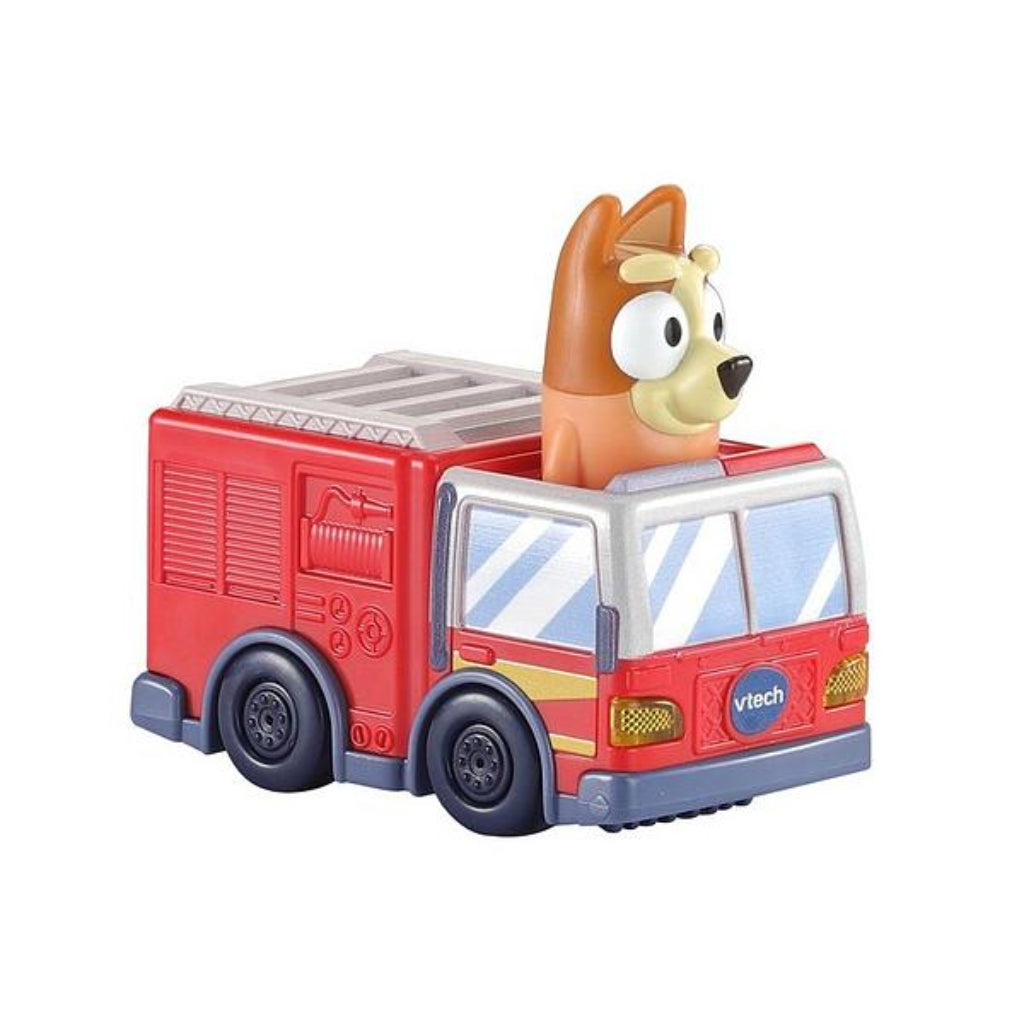 A VTech toy fire truck with a cartoon dog character peeking out from the vehicle