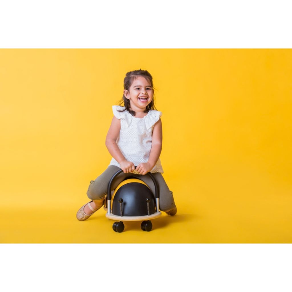 Close-up of the wipe-clean yellow and black striped cover on the Wheely Bug bee ride-on